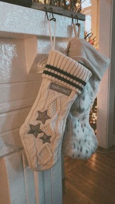 a stocking hanging from a fireplace in front of a christmas tree