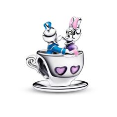 a teacup with two rabbits in it and hearts on the side, sitting on top of