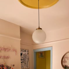 a room with a yellow door and some flowers on the table in front of it