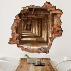 an old brick wall with a wooden table and chairs in front of it that has been torn open