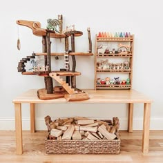 a wooden table topped with lots of different types of toys and shelves filled with wood