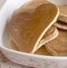 heart shaped pancakes in a white bowl on a table