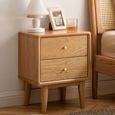 a wooden night stand with two drawers and a lamp