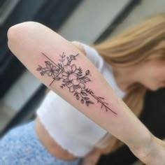 a woman with a flower tattoo on her arm