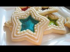 some cookies are on a white plate with blue and green frosting in the shape of stars