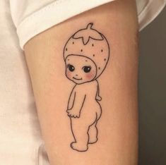 a person with a small tattoo on their arm that has a drawing of a bear in the shape of a strawberry