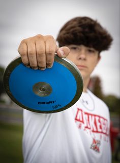 a young man holding a blue disc in his hand