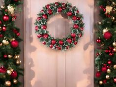 two christmas wreaths hanging from the side of a door with red and gold ornaments