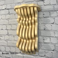 a wooden wall hanging on the side of a brick building with wavy lines carved into it