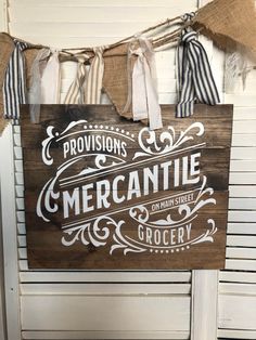 a wooden sign hanging from the side of a door that says provisions mercantile on man - made grocery