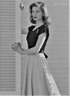 black and white photograph of a woman leaning against a wall with her hand on the door handle