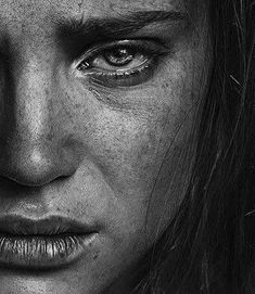 a black and white photo of a woman's face with freckles on