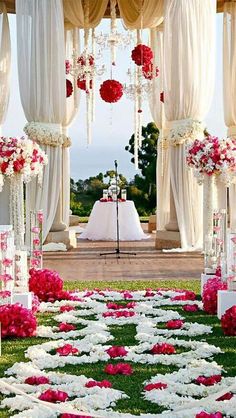 an outdoor wedding setup with white and pink flowers on the aisle, decorated with draping