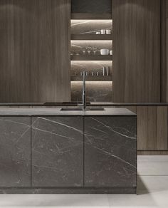 a modern kitchen with marble counter tops and dark wood cabinetry, along with stainless steel appliances