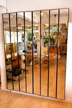 a large mirror in the middle of a room with chairs and other furniture on it