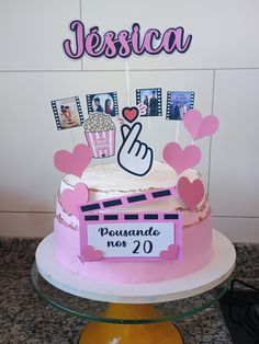 a cake with pink frosting and pictures on top that says jesica pousando nos 20