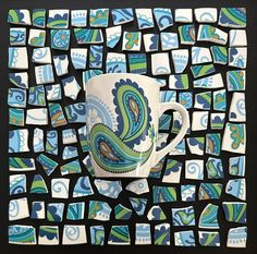 a coffee cup is surrounded by blue and green tiles