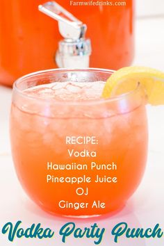 an orange drink in a glass with a lemon wedge on the rim next to a bottle of vodka party punch