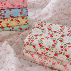 four different colored fabrics are stacked on top of each other, with flowers all over them