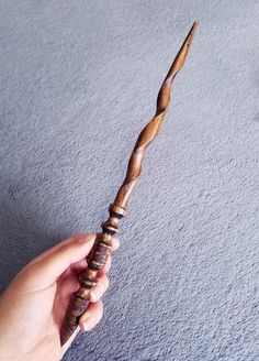 a person holding a wooden stick in their hand on the carpeted floor with grey walls