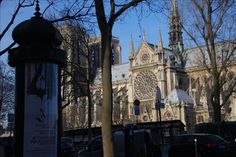 an old cathedral is shown in the background with cars parked on the street below it