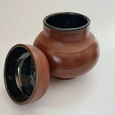 two brown vases sitting next to each other on a table