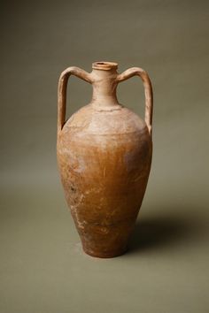 an old brown vase sitting on top of a table