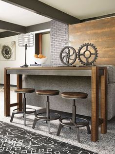 a table with three stools in front of it and a clock on the wall