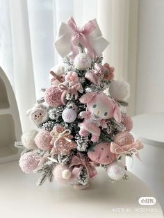 a small pink christmas tree with teddy bears on it's sides and bows around the top