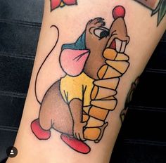 a cartoon mouse tattoo on the leg