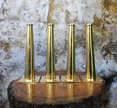 three gold candles are sitting on a wooden stand