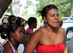 a woman in a red dress standing next to other people