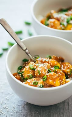 two white bowls filled with food on top of a table