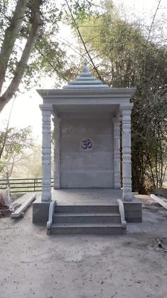 a small white structure sitting in the middle of a park with steps leading up to it