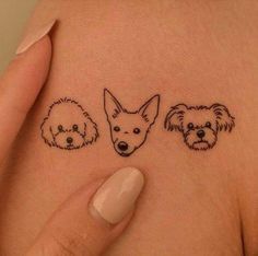 three small dogs on the side of a woman's stomach, with their faces drawn in black ink