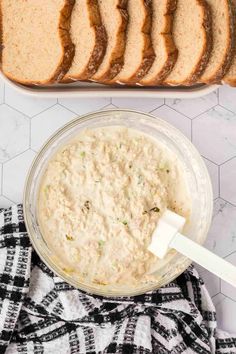 a loaf of bread sitting on top of a counter next to a bowl of dip