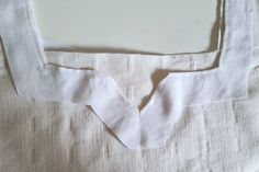 a white piece of cloth with some small holes in the middle and one hole at the bottom