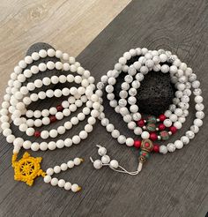 Beautiful Howlite Mala from Nepal and Mountain shell beads Mala necklace. You can choose between the mala that is made with howlite beads (white with gray) and mix metal beads from Nepal, or the all white mala necklace, which is made with mountain shell beads and a yellow mantra symbol. A unique praying mala that can be used as a necklace or as an ornament. The mala has no clasp, you wear it over the head. --The Mala with the metal beads and the red beads has a total length of 48.2cm- 19 inch lo Buddhist Mala, Wiccan Necklace, Yoga Lover Gift, Beads Mala, 108 Mala Beads, Mens Necklace, Red Beads, Yoga Gifts, Skull Necklace