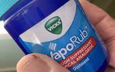 a hand holding a bottle of vapo rub