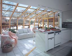 an open kitchen and living room area with white tile flooring, large windows, and lots of natural light