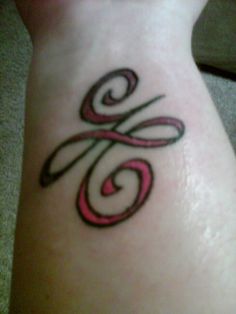 a woman's foot with a tattoo design on the side of her leg, which is pink and black