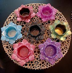 there are many different colored flowers on the doily that is sitting on the table