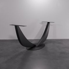 two black tables sitting on top of each other in front of a white wall and floor