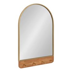 an arched mirror with three hooks on the bottom and a wooden shelf underneath it, against a white background