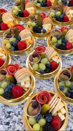 many small bowls filled with different types of fruit and crackers on top of a table