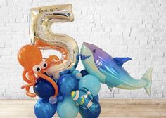 the number five balloon sculpture has an octopus, shark, and seahorse on it