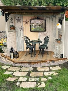 an outdoor patio with chairs, table and potted plants on the side of it