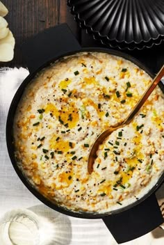 a bowl filled with rice on top of a table next to silverware and plates