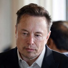 a close up of a person in a suit and tie looking off to the side