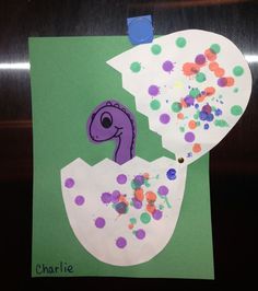 a child's handprinted picture of a purple bird in an egg with sprinkles